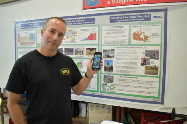Mike Parsons, PhD, tient son téléphone intelligent devant son exposition à #BIOExpo17. Les téléphones intelligents sont pleins de terres rares!