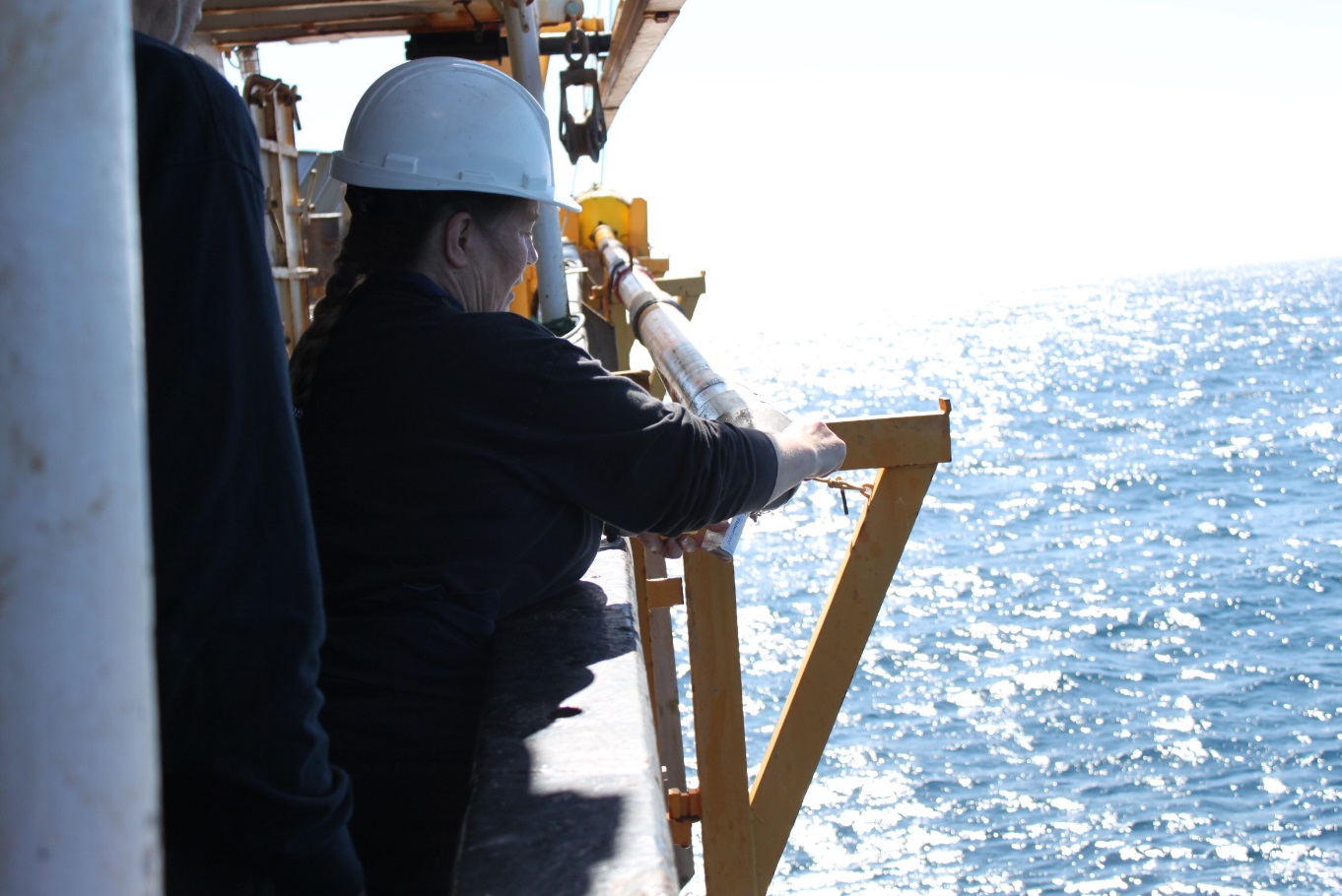 Kate Jarrett, de la CGC – Atlantique, procédant à un sous-échantillonnage de la base d’une carotte de sédiments marins à bord du navire de la Garde côtière canadienne (NGCC) Hudson