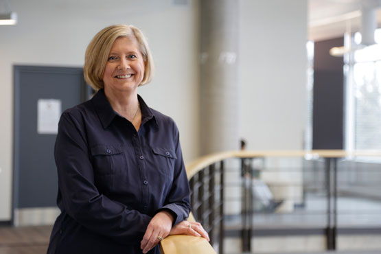 Une femme en tenue civile se tient à côté d'une balustrade