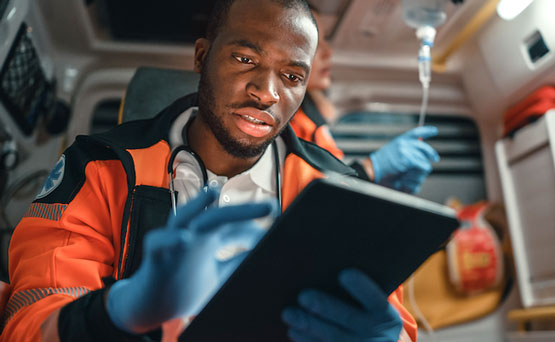 Un ambulancier paramédical utilise une tablette à bord d’une ambulance.