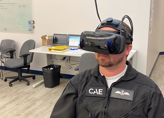 Une personne vêtue d’une combinaison noire utilise un casque de réalité virtuelle.