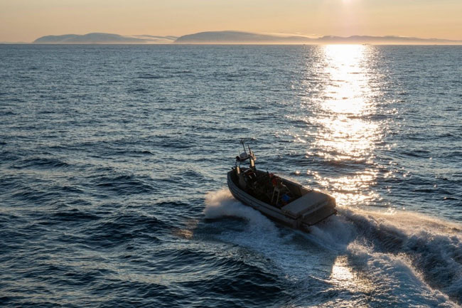 A boat on wavy water at sunset