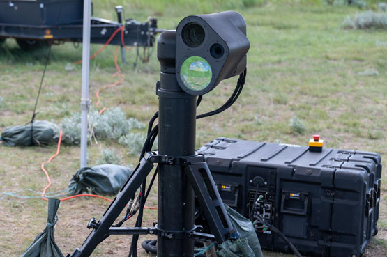 Système laser antidrone menu d’une lentille et monté sur trépied.