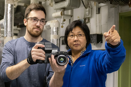 Deux personnes utilisent une caméra thermique dans un local technique.