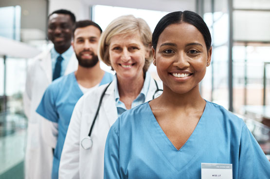 Quatre professionnels de la santé debout sur leur lieu de travail