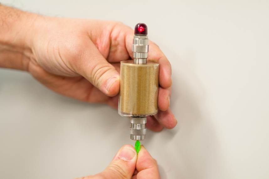 Ce dispositif nous permet de vérifier toute pointe d’un jouet ou toute pièce qui s’est détachée d’un jouet afin de nous assurer qu’elle ne peut couper la peau. Ce morceau de plastique vert s’est détaché d’un jouet qu’on a laissé tomber (voir 7. Ils se brisent lorsqu’on les échappe). La lumière rouge de l’instrument dans la photo indique que la pièce est trop pointue!