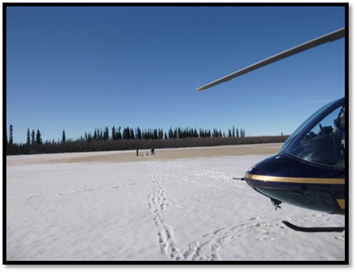 Kimberley and Mitchell collecting water and sediment samples from under the lake ice during their pre-ice out helicopter survey of 23 lakes within The Delta.