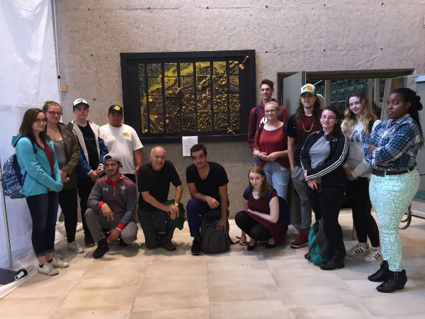 La classe Oceans 11 du J.L. Ilsley High School, printemps 2017, accompagnée de son professeur Frank van Blacorn (centre gauche), devant une réplique de fond marin donnée à l’Institut océanographique de Bedford.